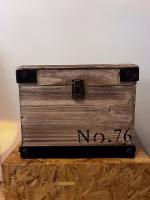 Modern wood storage box with dark steel corner accents and black lettering, styled as functional industrial decorative storage