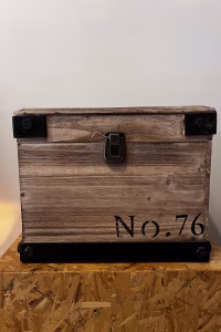 Modern wood storage box with dark steel corner accents and black lettering, styled as functional industrial decorative storage