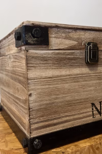 Modern wood storage box with dark steel corner accents and black lettering, styled as functional industrial decorative storage