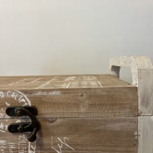 Country style wooden storage chest with a natural wood finish and decorative white word patterns on the sides, used as versatile rustic furniture