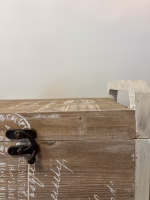 Country style wooden storage chest with a natural wood finish and decorative white word patterns on the sides, used as versatile rustic furniture