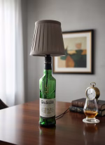 Handmade side lamp crafted from a Glenfiddich repurposed spirit bottle with a fabric lampshade, displayed as unique sustainable lighting decor