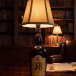 Handmade side lamp crafted from a J&B repurposed spirit bottle with a fabric lampshade, displayed as unique sustainable lighting decor