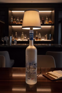 Handmade side lamp crafted from a Grey Goose repurposed spirit bottle with a fabric lampshade, displayed as unique sustainable lighting decor