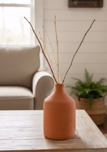 Group of three hand-turned Lebanese terracotta vases in various sizes with a raw matte finish, styled with dried olive branches in a modern Mediterranean home