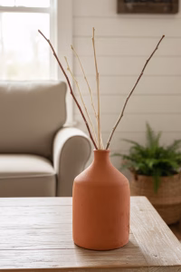 Group of three hand-turned Lebanese terracotta vases in various sizes with a raw matte finish, styled with dried olive branches in a modern Mediterranean home