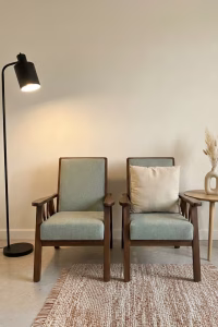1950s style solid walnut armchair with straight-lined frame and light green upholstery, newly restored and professionally upholstered