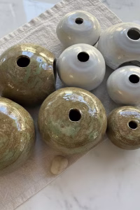 Transform your shelves with this set of 8 handmade ceramic orbs. Featuring a mix of Japandi-style sage and matte white glazes, these artisanal sculptures are the perfect minimalist table centerpiece in Lebanon. Order your set from Rockfort.