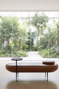 Contemporary 162cm capsule-shaped bench in black cow leather with an integrated matte black steel side table, modern furniture for a luxury entryway