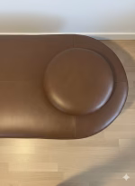 Contemporary 162cm capsule-shaped bench in black cow leather with an integrated matte black steel side table, modern furniture for a luxury entryway