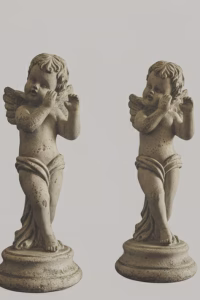 Pair of classical cherub statues with a distressed weathered stone finish, standing on circular plinths, styled on a white mantelpiece