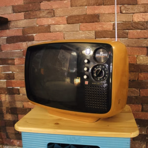 Vintage 1970s Panasonic TR-542A Space Age television in mustard yellow ochre, featuring a rounded solid state body and original knobs