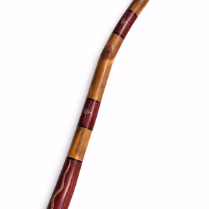 Premium master-crafted Aboriginal didgeridoo featuring bold ochre-toned bands and traditional lizard motifs set against deep earth-red panels from RockFort Lebanon