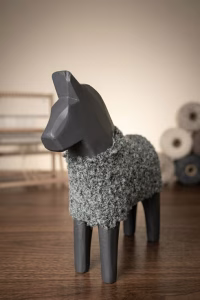 Modern minimalist wooden horse sculpture with a matte black finish and a hand-knitted textured wool coat from RockFort decor boutique in Lebanon.