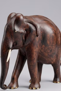 Hand-carved solid wood elephant sculpture with detailed natural grain, delicate inlay work on the feet, and polished tusks from RockFort Lebanon.