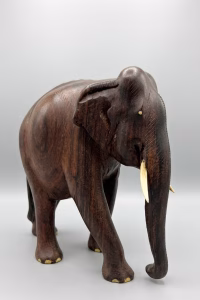 Hand-carved solid wood elephant sculpture with detailed natural grain, delicate inlay work on the feet, and polished tusks from RockFort Lebanon.