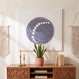 Large hand-embroidered textile wall hanging featuring a navy blue circular mandala and moon-phase design on a white fabric base from RockFort boutique in Lebanon.