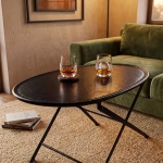 Sophisticated oval foldable coffee table with a hand-stitched black leather top and minimalist metal frame from RockFort vintage furniture store in Lebanon.