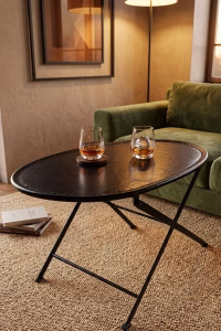 Sophisticated oval foldable coffee table with a hand-stitched black leather top and minimalist metal frame from RockFort vintage furniture store in Lebanon.