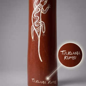 Premium master-crafted Aboriginal didgeridoo featuring bold ochre-toned bands and traditional lizard motifs set against deep earth-red panels from RockFort Lebanon