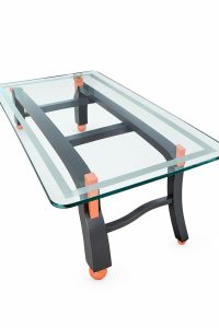 Contemporary architectural glass coffee table with a frosted border glass top, charcoal grey frame and salmon orange corner joints from RockFort Lebanon.