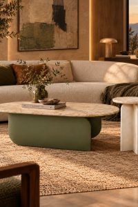 Travertine-effect coffee table with curved olive green base and cream side table styled in a warm modern living room from RockFort Lebanon.