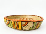 Side view of the handmade Warli papier-mâché bowl showing hand-painted orange, yellow and green geometric bands from RockFort Lebanon.